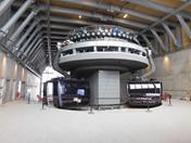 Teleféricos modernos e imponentes, reforçados por vigas de aço e cobertura de madeira, projetados para otimizar o transporte em montanha.