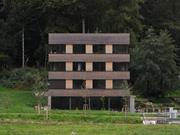 Vista frontal da Torre da floresta em Friburgo, um cubo simples de madeira e vidro integrado na natureza