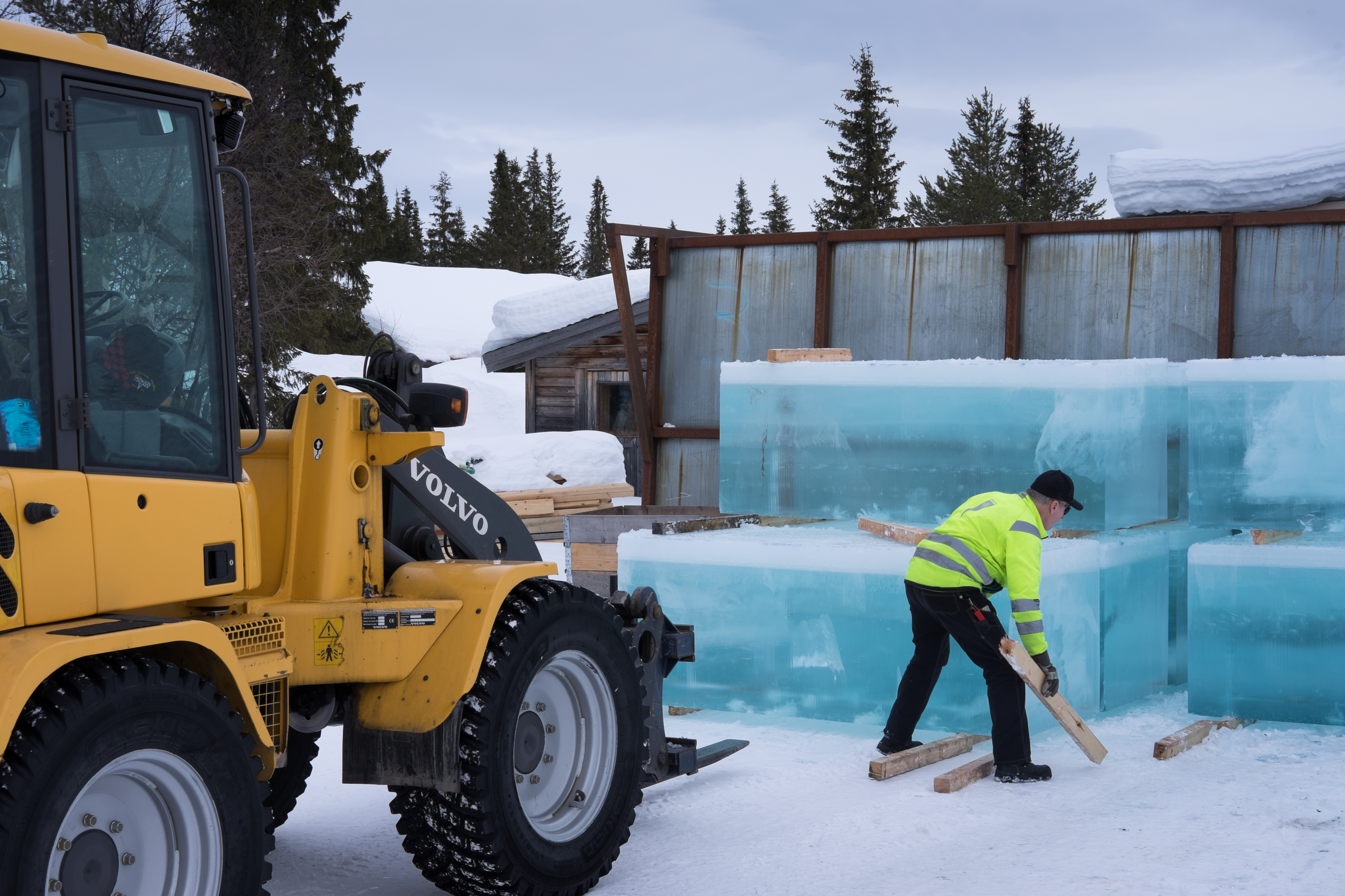 Trabalhadores colocando blocos de gelo na reconstrução do IceHotel na Suécia