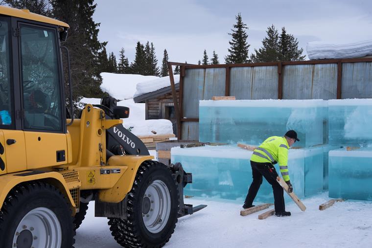 Trabalhadores colocando blocos de gelo na reconstrução do IceHotel na Suécia