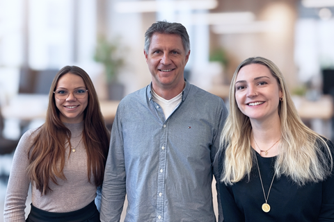 Uma equipa de marketing a colaborar de forma empenhada num escritório bem iluminado, envolvida em discussões dinâmicas e em sessões de brainstorming em torno de uma grande mesa.