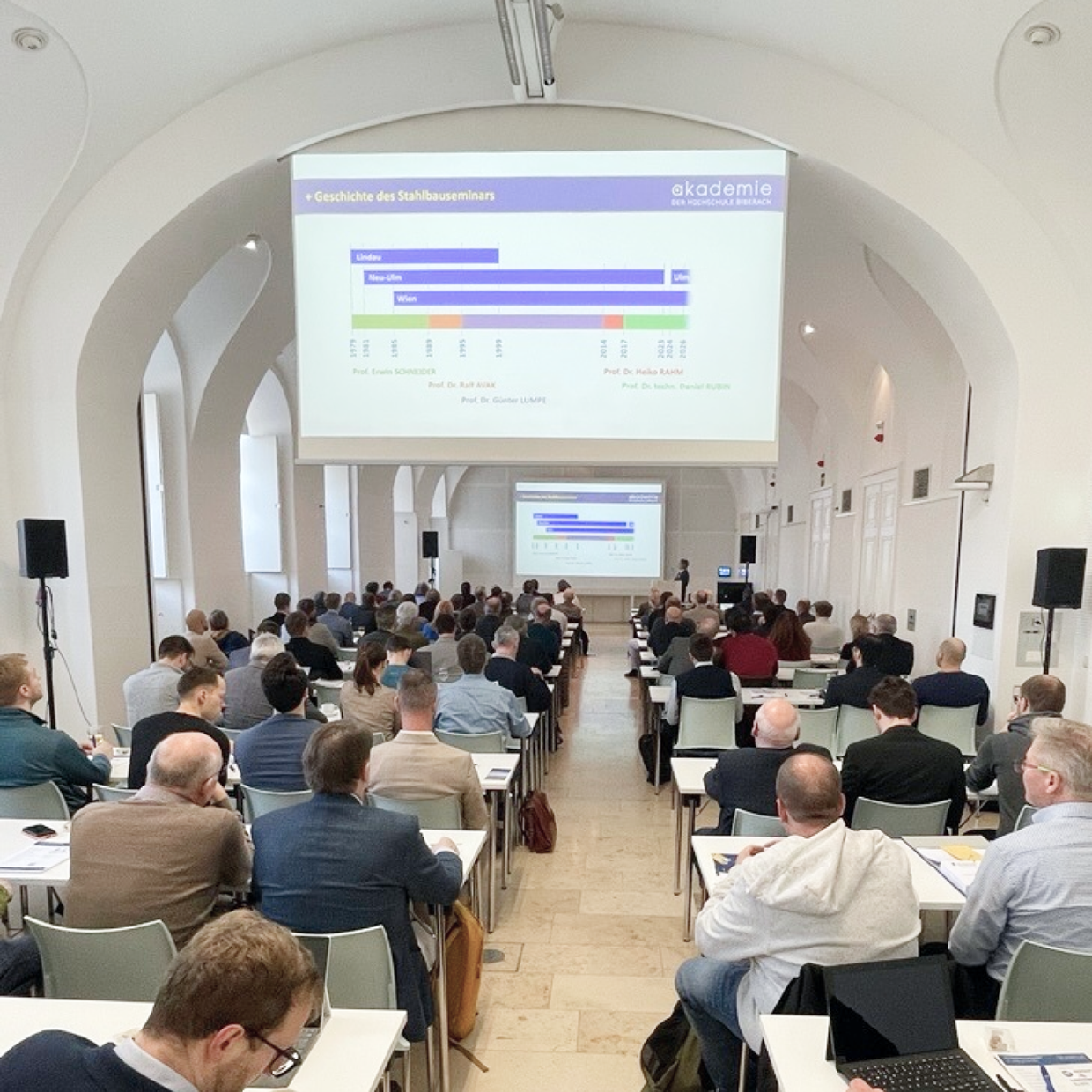 Participantes a discutir temas de engenharia de estruturas num seminário em Viena.