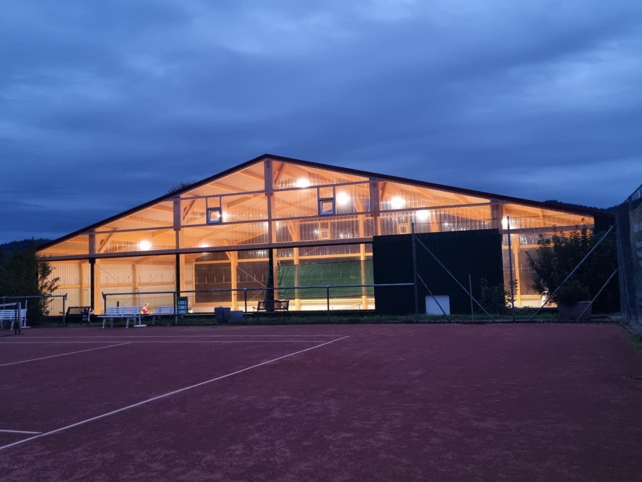 Foto panorâmico do pavilhão de ténis no Odenwald, parte do Bob-Clube de Fürth, rodeado por áreas verdes.