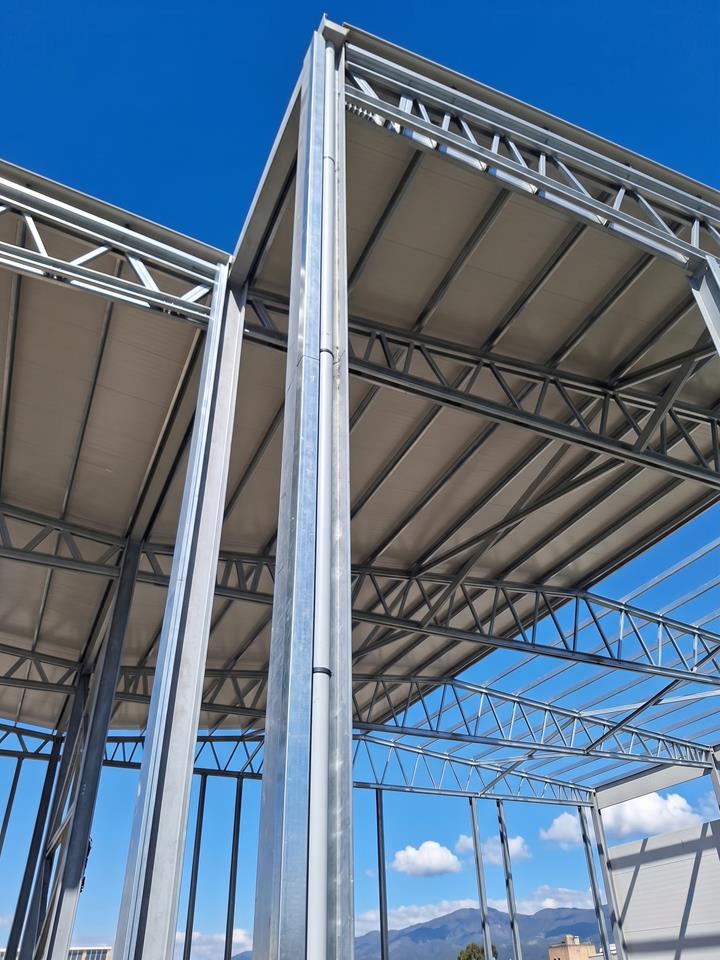 Armazém industrial localizado em Macchiareddu, Sardenha, apresentando elementos de construção em aço.